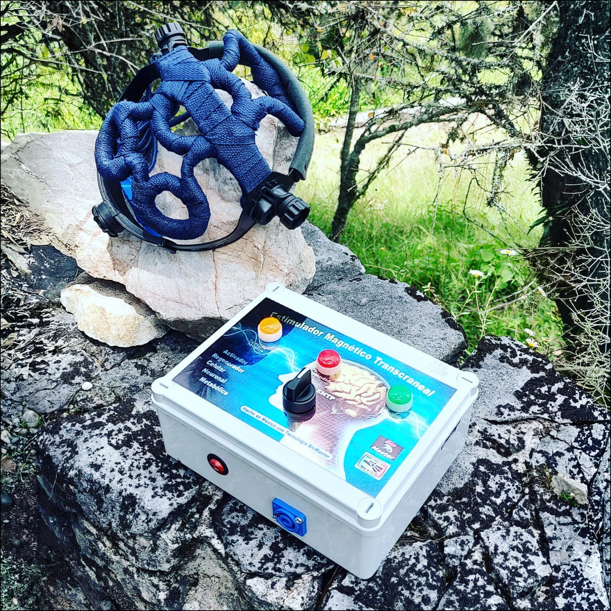 QuantumMind TMS Helmet and control unit by TECHBEMS México resting on rocks outdoors