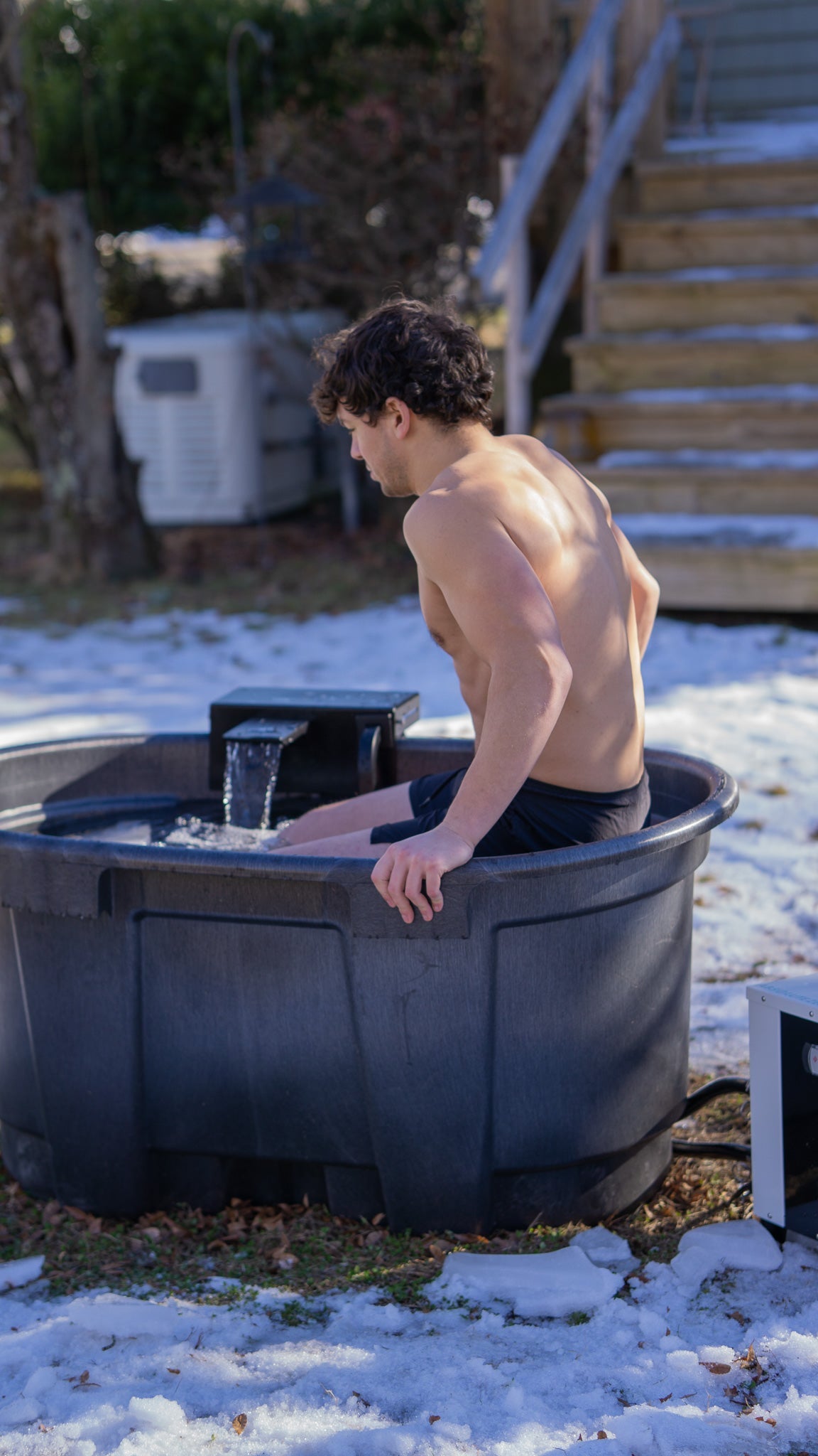 Person using AZ-Adapt stock tank plunge outdoors in winter